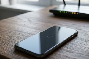 Смартфон с экраном загрузки рядом с Wi-Fi роутером